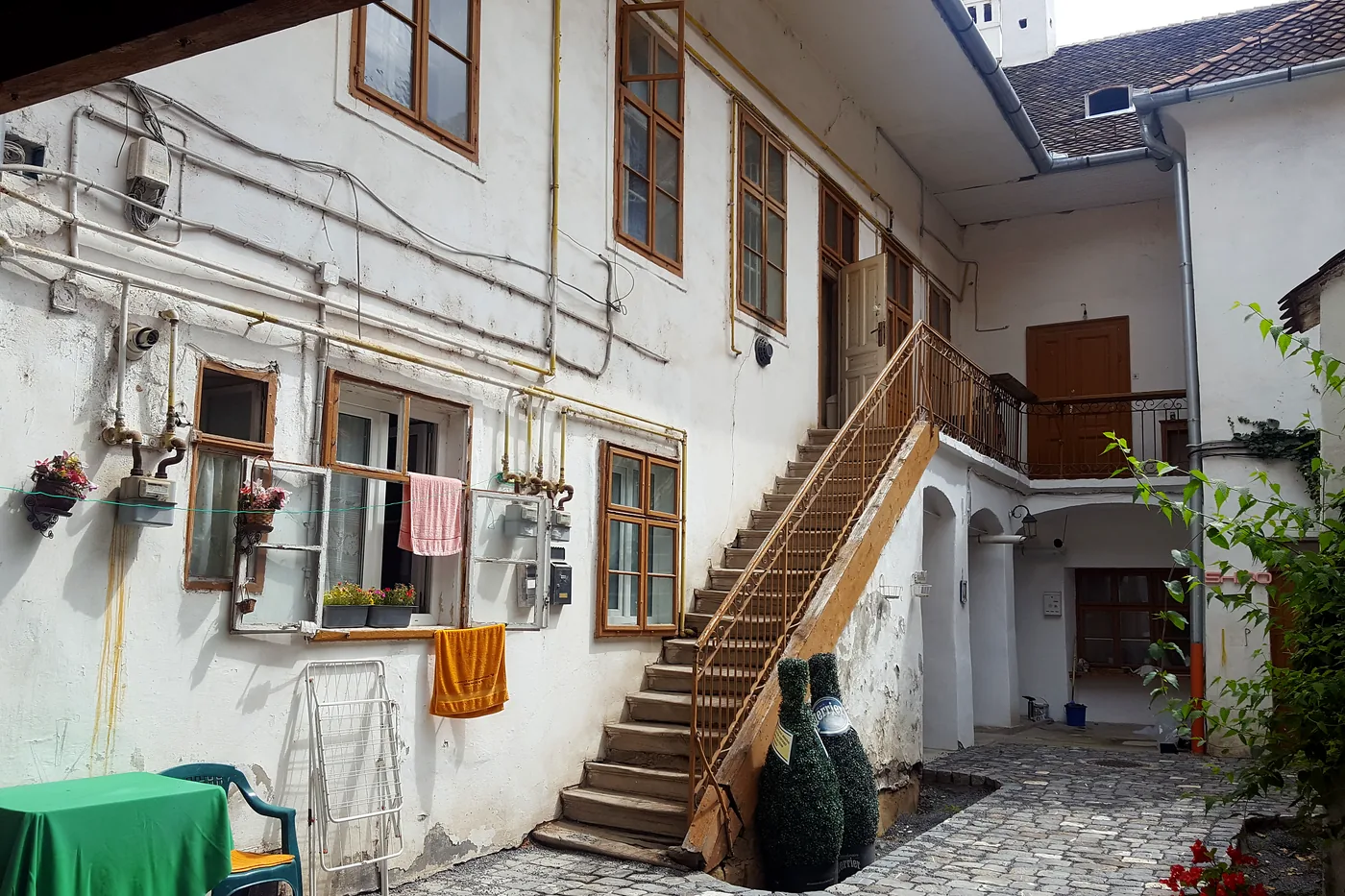 Der Innenhof des Hauses mit steinerner Freitreppe und hölzerner Laube